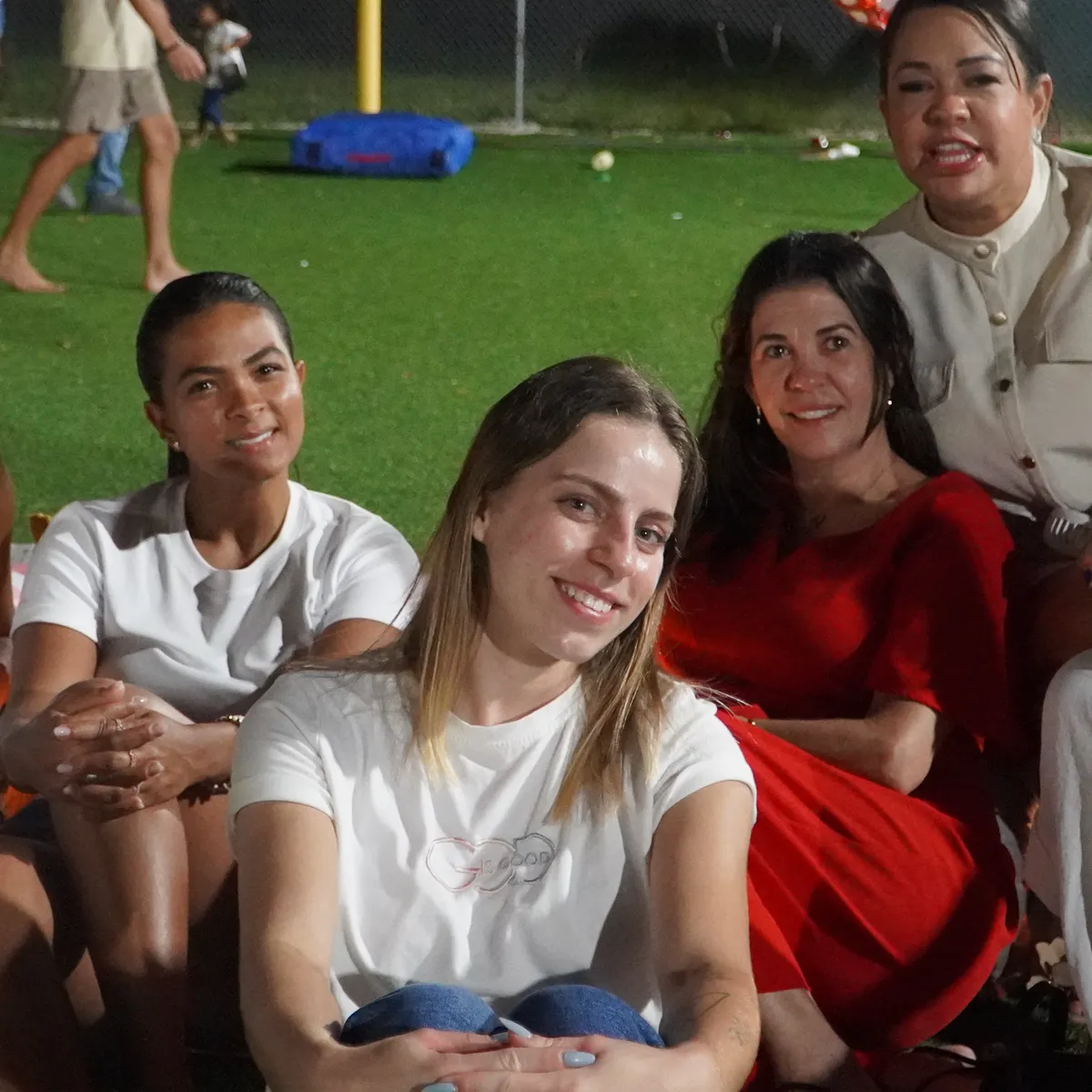 Mulheres do New Hope Casa reunidas na grama durante um encontro da igreja