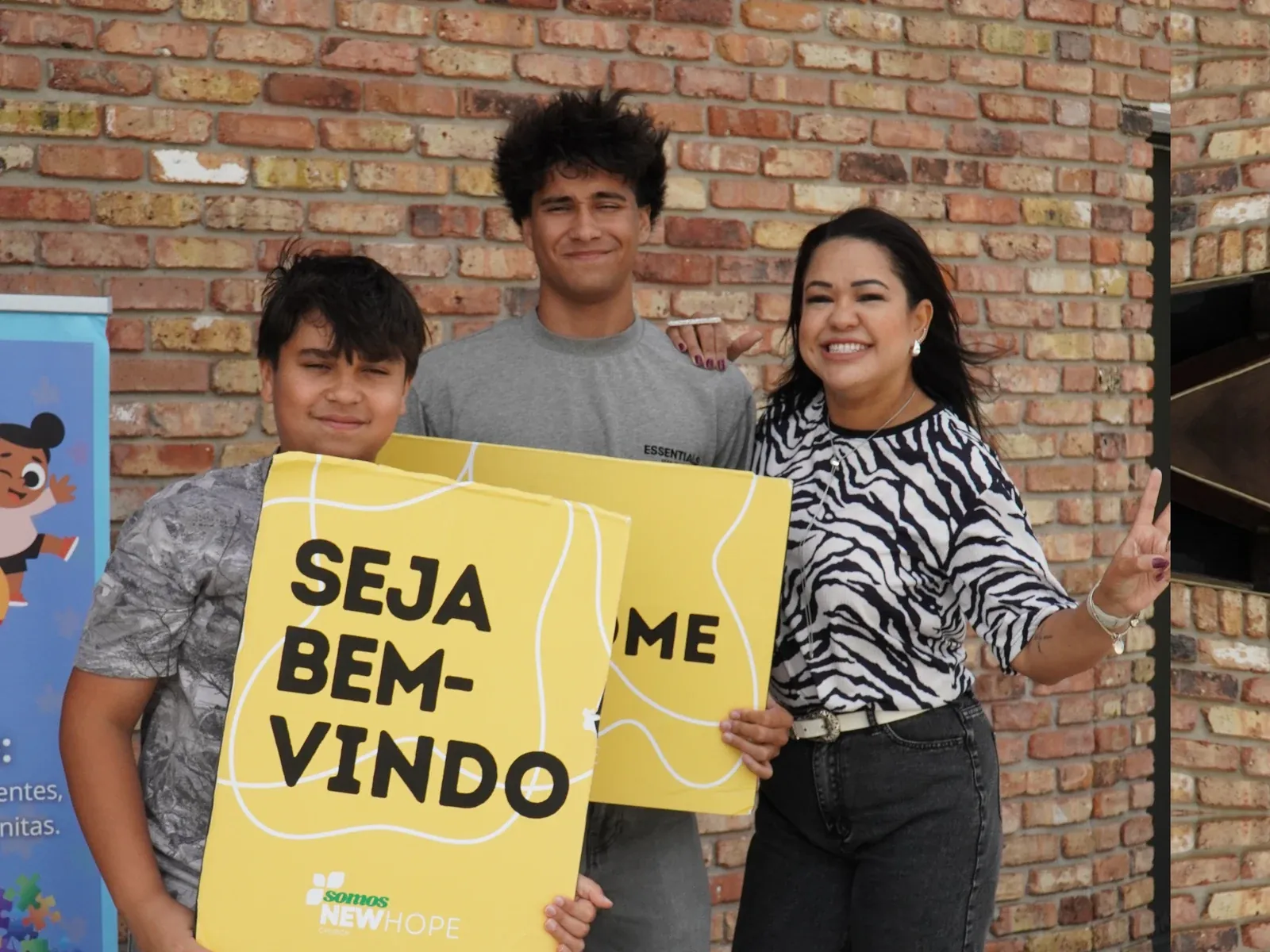 A equipe de recepção da New Hope Church com a placa de boas-vindas