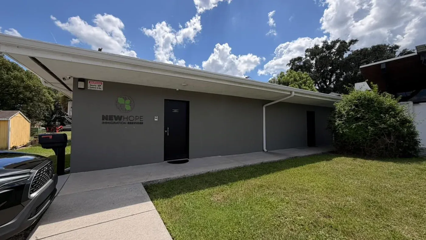 Fachada do New Hope Office of Immigration Services em Orlando, com a placa da marca na parede