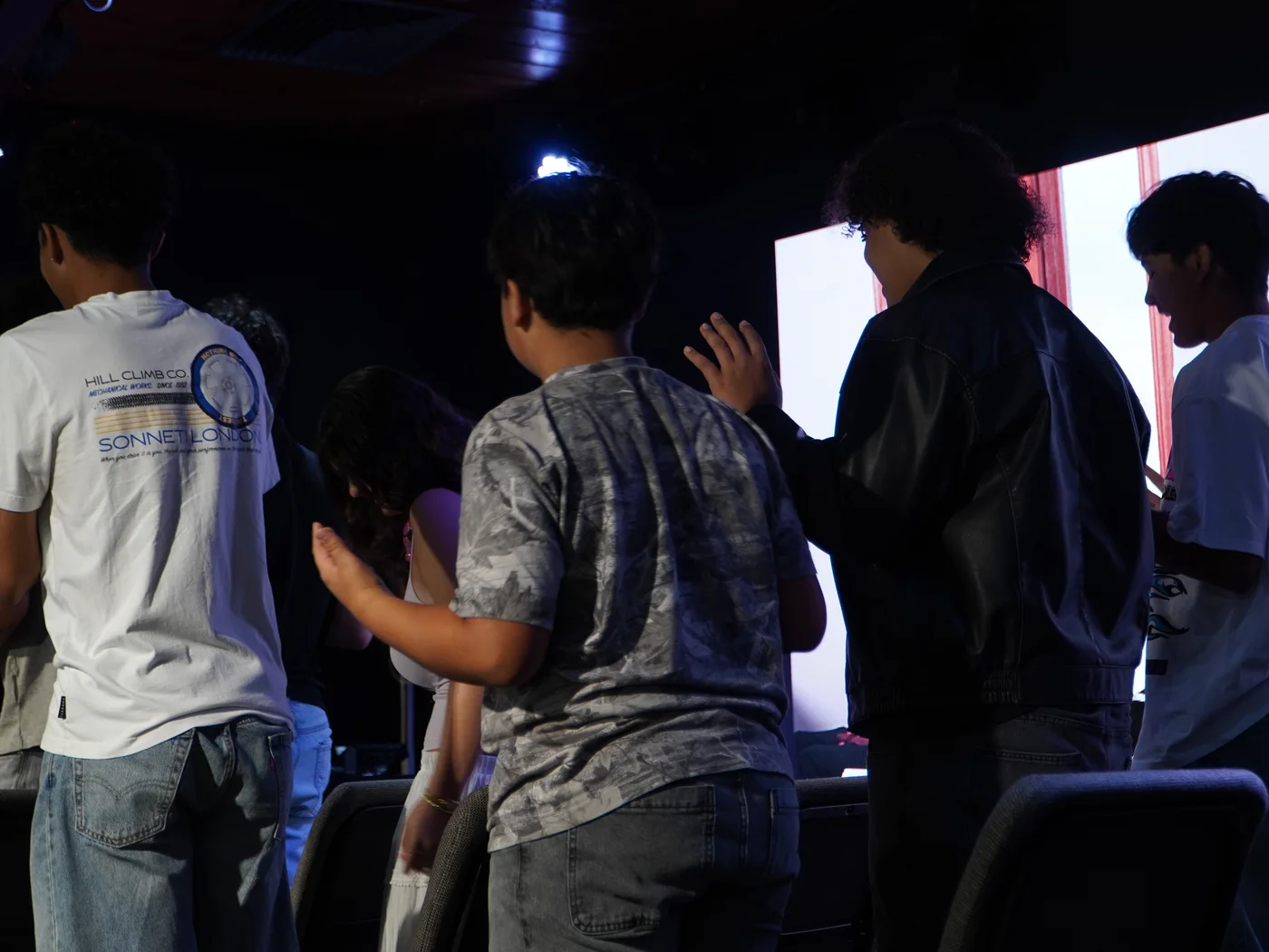 Adolescentes do Forever Youth servindo na mesa de mídia durante o culto